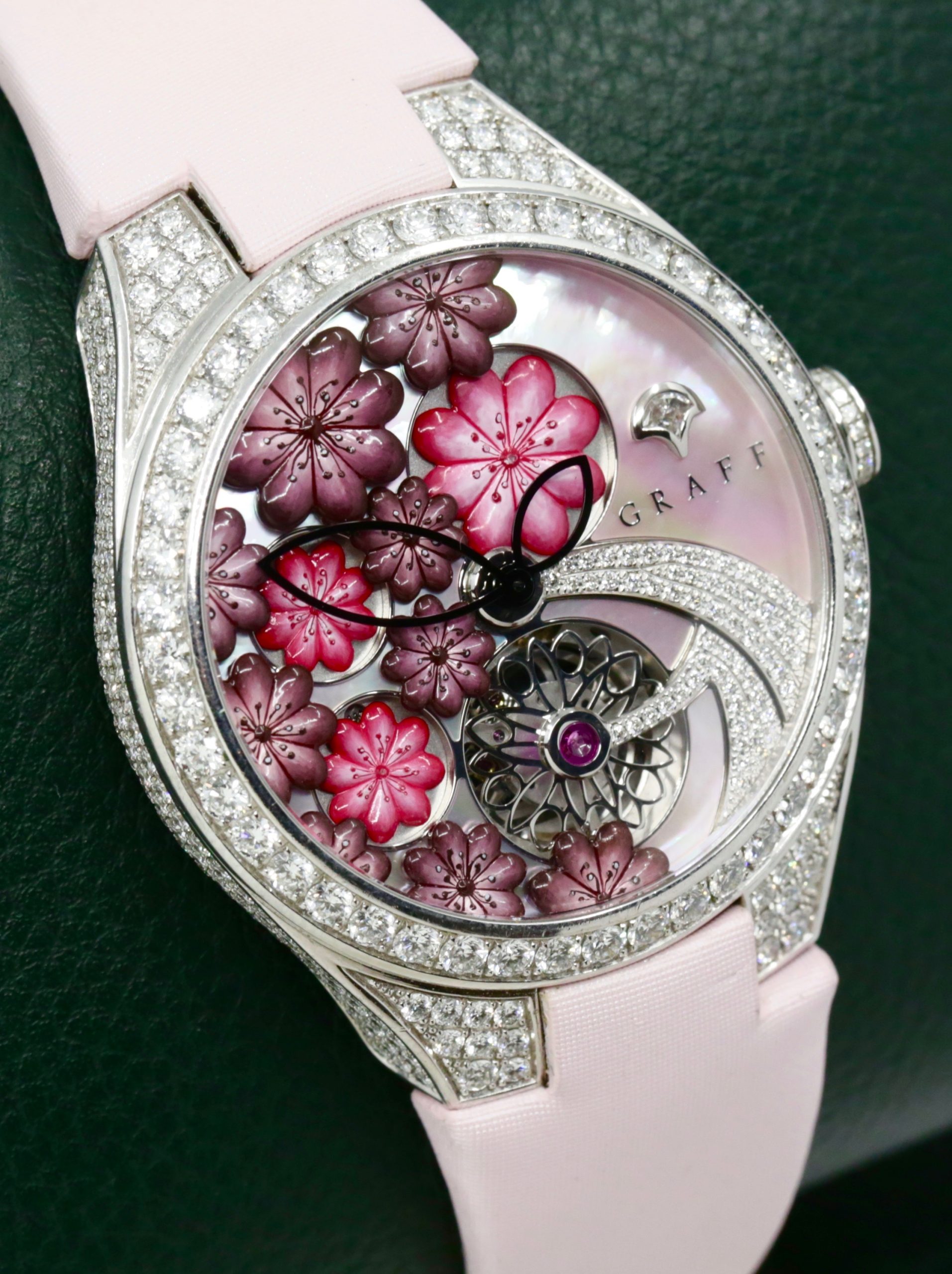 The Graff Floral Automatic Watch in 18ct White Gold, Set with Factory Diamonds on the Case, Lugs, Crown and Bezel, with Mother of Pearl Dial Set with a Floral Design and Diamonds, on a Graff Satin Band with Factory Diamond Set Tang Buckle. Ref: GFA37WGSLD, Box, Book, Additional Graff Satin Strap and Graff Warranty Card.
